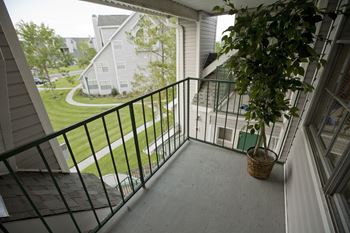 a plant sits on a balcony in front of a large window